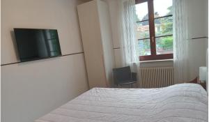 a bedroom with a bed and a tv on the wall at Family rooms with full kitchen in Lake Garda in Cavalcaselle