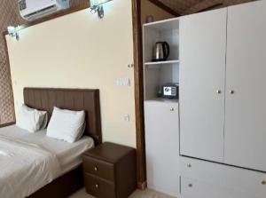 a small bedroom with a bed and a cabinet at Rum Aranda camp & Jeep Tour in Wadi Rum