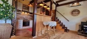 a kitchen with wooden floors and a staircase with stools at Chalet Vito - Where Luxury Meets Tranquility in Gregurić Breg