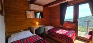 a small room with two beds and a window at Chalet Vito - Where Luxury Meets Tranquility in Gregurić Breg