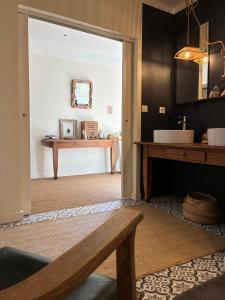 a bathroom with a sink and a bench in a room at ferme st pierre 2 suites avec repas, piscine, clim, cheminée ou baignoire spa in Chabeuil