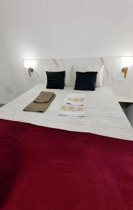 a bedroom with a white bed with a red blanket at Pousada Gaturama Village in Corumbá