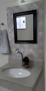 a bathroom sink with a mirror on a counter at Sobrado 4 amplo e confortável in Corumbá +37 photos
