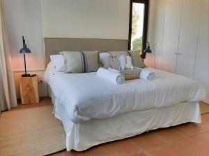 a bedroom with a large white bed with towels on it at Casapueblo Rent Cachagua CP 27 in Cachagua