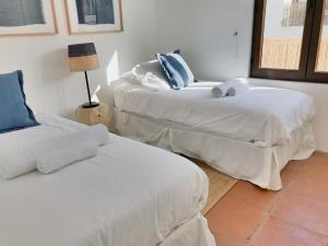two beds with white sheets in a room at Casapueblo Rent Cachagua CP 27 in Cachagua