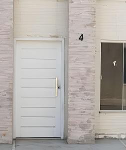 a white garage door next to a brick wall at Sobrado 4 amplo e confortável in Corumbá