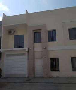 a white house with two garage doors and windows at Sobrado 4 amplo e confortável in Corumbá