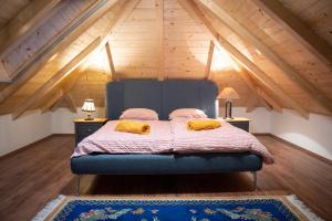 a bedroom with a blue bed in a attic at Balaton Cottage - Your Hide Away in Cserszegtomaj
