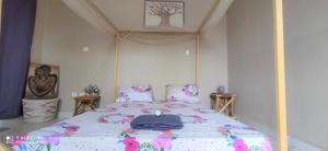 1 dormitorio con 1 cama con edredón morado en Zion, en Toubab Dialaw