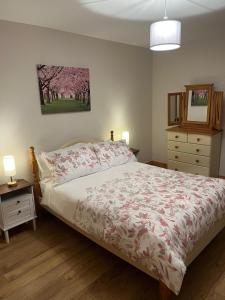 een slaapkamer met een bed en een dressoir met een sprei bij Belmullet Town Holiday Home in Belmullet