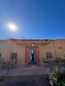 Un edificio con mesas y sillas delante. en DAR MIRA DUNES Hassilabiad-Merzouga, en Adrouine 44 fotos más