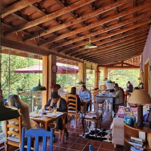 a group of people sitting at tables in a restaurant at Pousada Vale Monte Azul in Santo Antônio do Pinhal