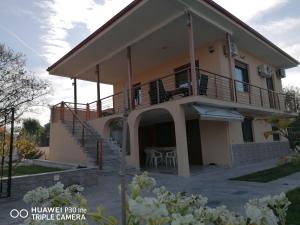 Una casa con balcón y escaleras al frente. en Villa Anastasia Nir, en Nea Iraklia