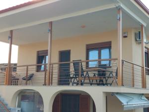 un balcón de una casa con sillas y mesas en Villa Anastasia Nir, en Nea Iraklia 19 fotos más