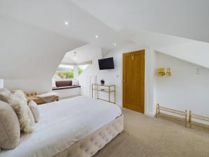 a white bedroom with a large bed and a television at Queen Elizabeth Penthouse Sleeps 6-8 in Stanhope