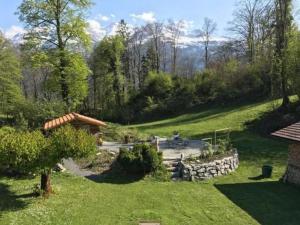 a garden with a stone wall and a building at Glyssen 22 Schwanden in Kienholz