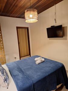 a bedroom with a blue bed with a towel on it at Pousada Schueng in Trindade