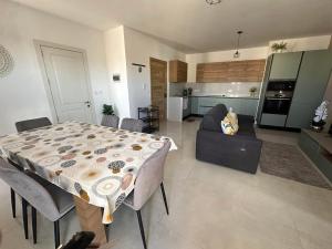 a kitchen and a living room with a table and a couch at Penthouse with Jacuzzi -Sannat in Sannat +11 photos