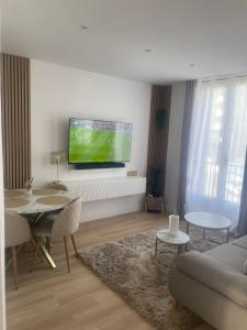 a living room with a flat screen tv on a wall at Appartement Jacuzzi proche Cité Gastronomique in Dijon
