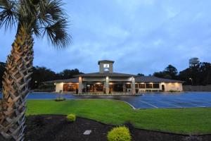 a building with a palm tree next to a tennis court at Best Western Point South in Yemassee