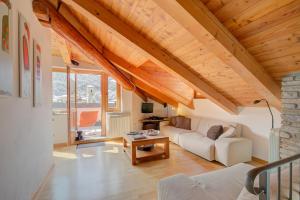 ein Wohnzimmer mit einer weißen Couch und einem Tisch in der Unterkunft Sunny Penthouse - Happy Rentals in Oulx