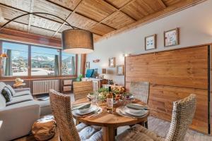 een eetkamer met een houten tafel en stoelen bij Studio Charming Sportinia - Happy Rentals in Sauze d'Oulx