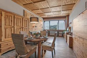 een eetkamer met een tafel en wat stoelen bij Studio Charming Sportinia - Happy Rentals in Sauze d'Oulx +11 foto's