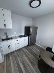 a kitchen with white cabinets and a black refrigerator at Empire Extended Stay in Webster +13 photos