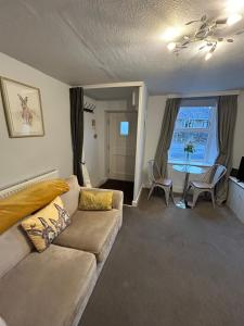 ein Wohnzimmer mit Sofa und Tisch in der Unterkunft 1, Bank End Cottages in Ingleton 