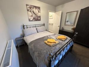 a bedroom with a bed with two towels on it at 1, Bank End Cottages in Ingleton