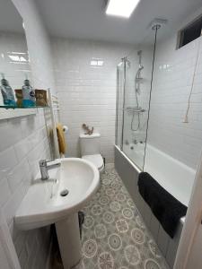 ein weißes Badezimmer mit Waschbecken und Dusche in der Unterkunft 1, Bank End Cottages in Ingleton 