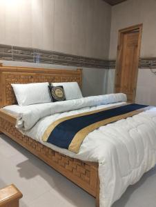 a large bed with a wooden frame in a room at Neelam Water View Hotel in Kundālshai
