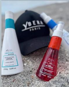 Una botella de protector solar junto a un sombrero en Hotel Gues, en La Guaca