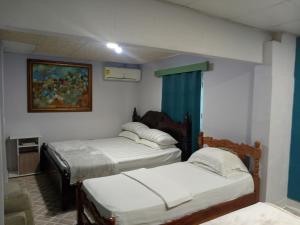 Una habitación con tres camas y un cuadro en la pared. en Hotel Gues, en La Guaca 35 fotos más