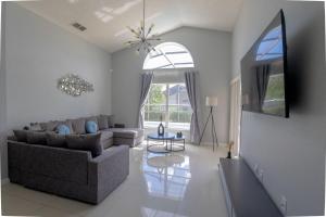 a living room with a couch and a tv at Casa Kissimmee in Orlando