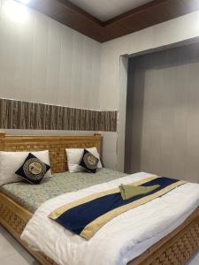a bedroom with a large bed with two pillows at Neelam Water View Hotel in Kundālshai