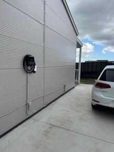 a white car parked next to a garage at Coastal Sanctuary, Spa, EV friendly, Pet Firendly with Fireplace, wood provided Just 50m to Kilcunda Beach and 100m to the Ocean View Hotel The Sticks and Copper Door Kitchen Accessibility Friendly in Kilcunda