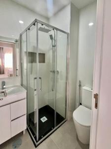 a bathroom with a shower with a toilet and a sink at T3 Moderno e Confortável in Praia +11 photos