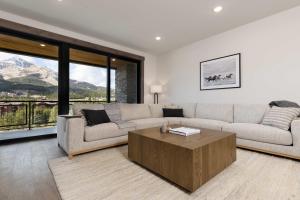 Una sala de estar con un sofá y una mesa de café. en Big Sky Base Camp Fireplace Views & Hot Tub, en Big Sky Mountain Village