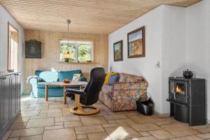 een woonkamer met een bank en een houtkachel bij 852-Bedsted-Thy-Istrupvej-35 in Stenbjerg