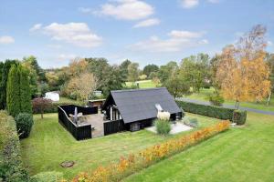 une maison noire au milieu d'une cour dans l'établissement N338-Karrebaeksminde-Strandskadevej-1, à Enø By