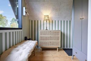 une chambre avec un lit et une lampe sur une commode dans l'établissement N338-Karrebaeksminde-Strandskadevej-1, à Enø By