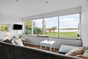 a living room with a couch and large windows at 30194-Malling-Fjordvej-26 in Norsminde