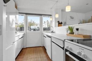 a white kitchen with white cabinets and a large window at 30194-Malling-Fjordvej-26 in Norsminde +28 photos