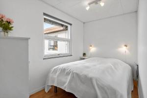 a white bedroom with a bed and a window at 30194-Malling-Fjordvej-26 in Norsminde