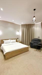 a bedroom with a large white bed and a couch at فيلا آنسي Villa Annecy in AlUla +19 photos