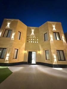 a large white building with a doorway at night at فيلا آنسي Villa Annecy in AlUla