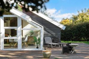 a house with a patio with chairs and a table at N334-Karrebaeksminde-Reedtzholmvej-127 in Enø By +15 photos