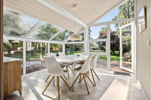 a dining room with a white table and white chairs at N334-Karrebaeksminde-Reedtzholmvej-127 in Enø By