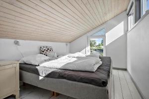 a large bed in a room with a wooden ceiling at N334-Karrebaeksminde-Reedtzholmvej-127 in Enø By